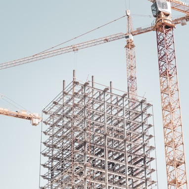 gray metal building frame near tower crane during daytime