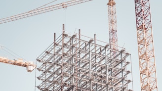 gray metal building frame near tower crane during daytime