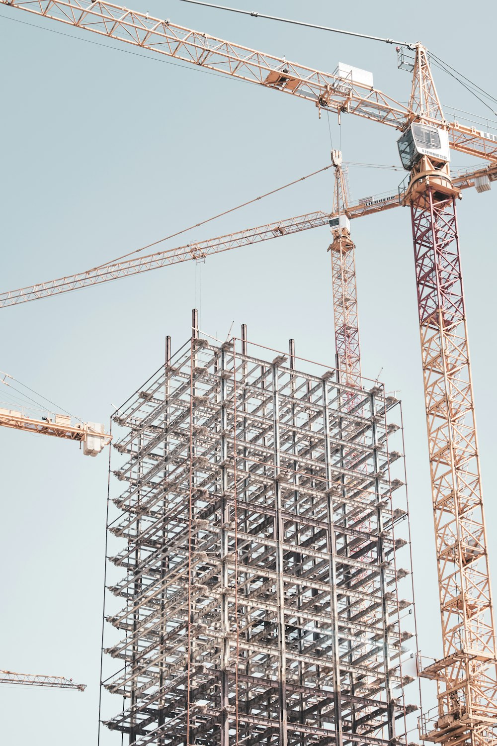 gray metal building frame near tower crane during daytime