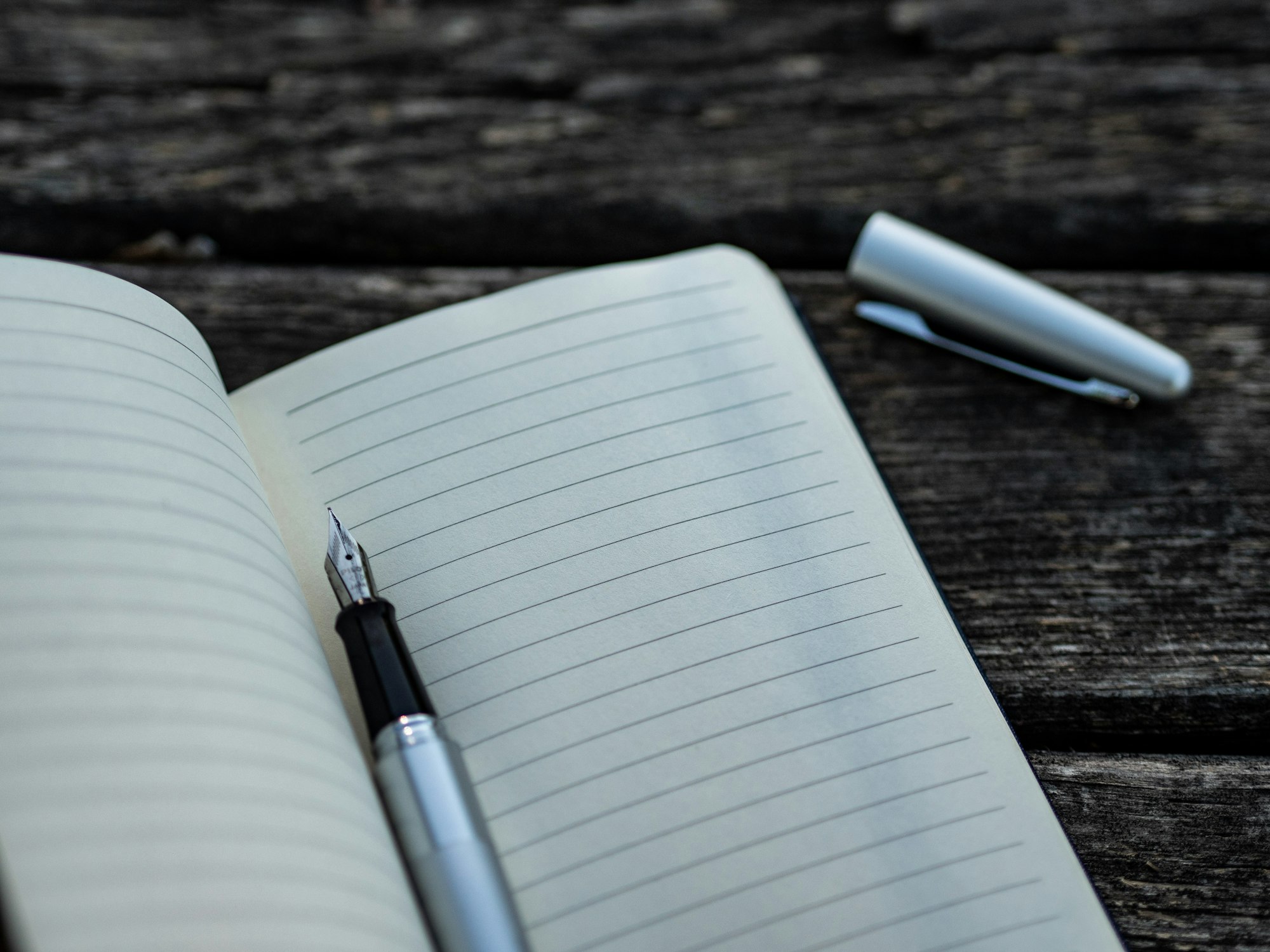 stylo plume gris et noir et cahier pou représenter le processus d'évaluation personnelle 