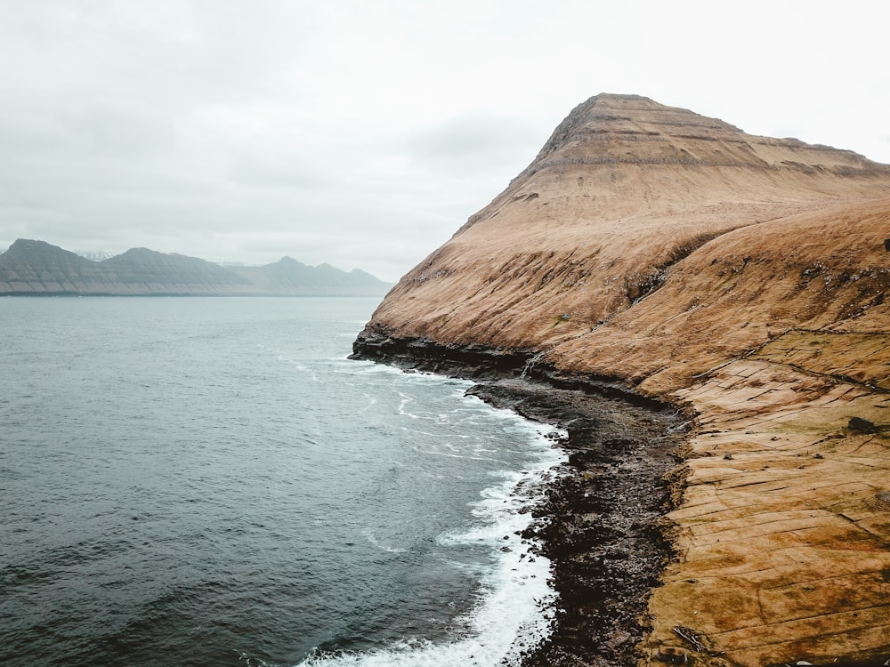 cliff near body of water during daytime