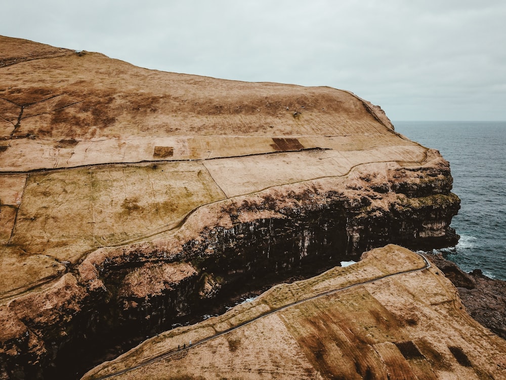 brown rock formation near ocean at daytime