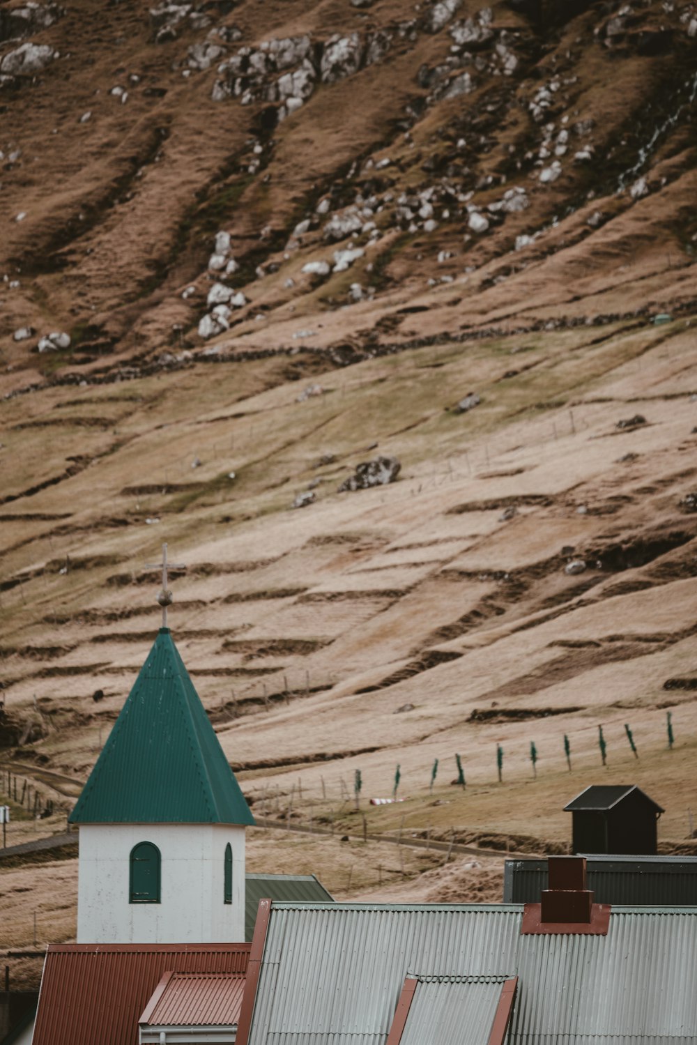 white and green building near the hill