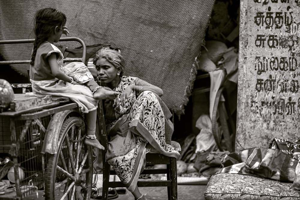 girl and woman sitting beside cart