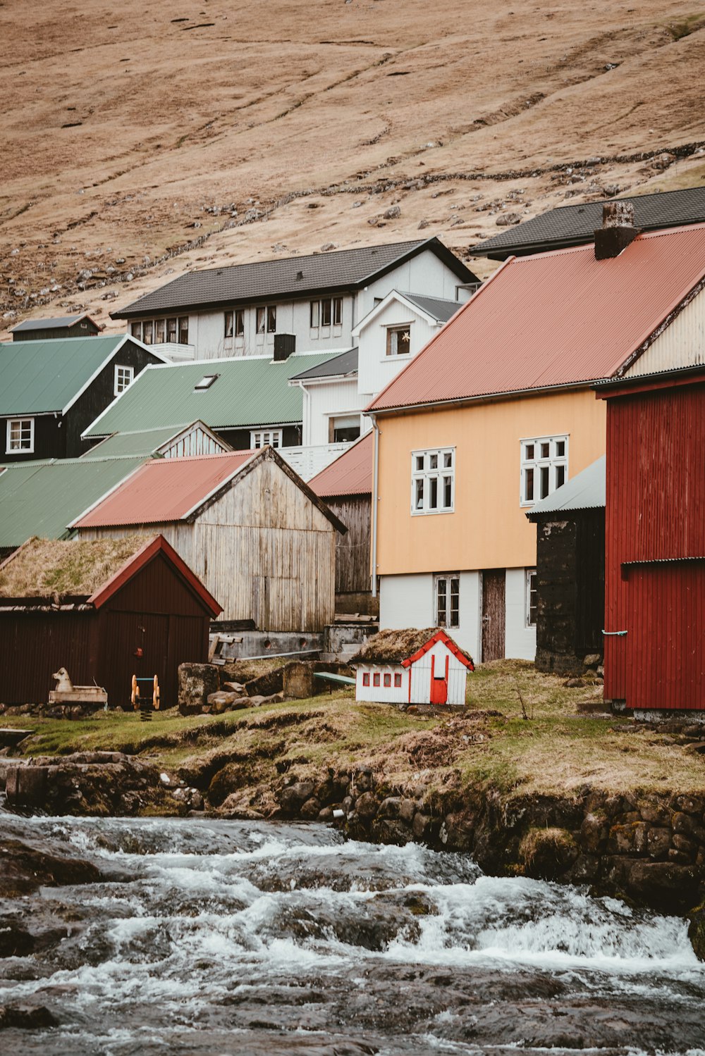 white, orange, and red houses near body of water