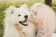A happy pet owner hugging their freshly groomed dog outside the salon.
