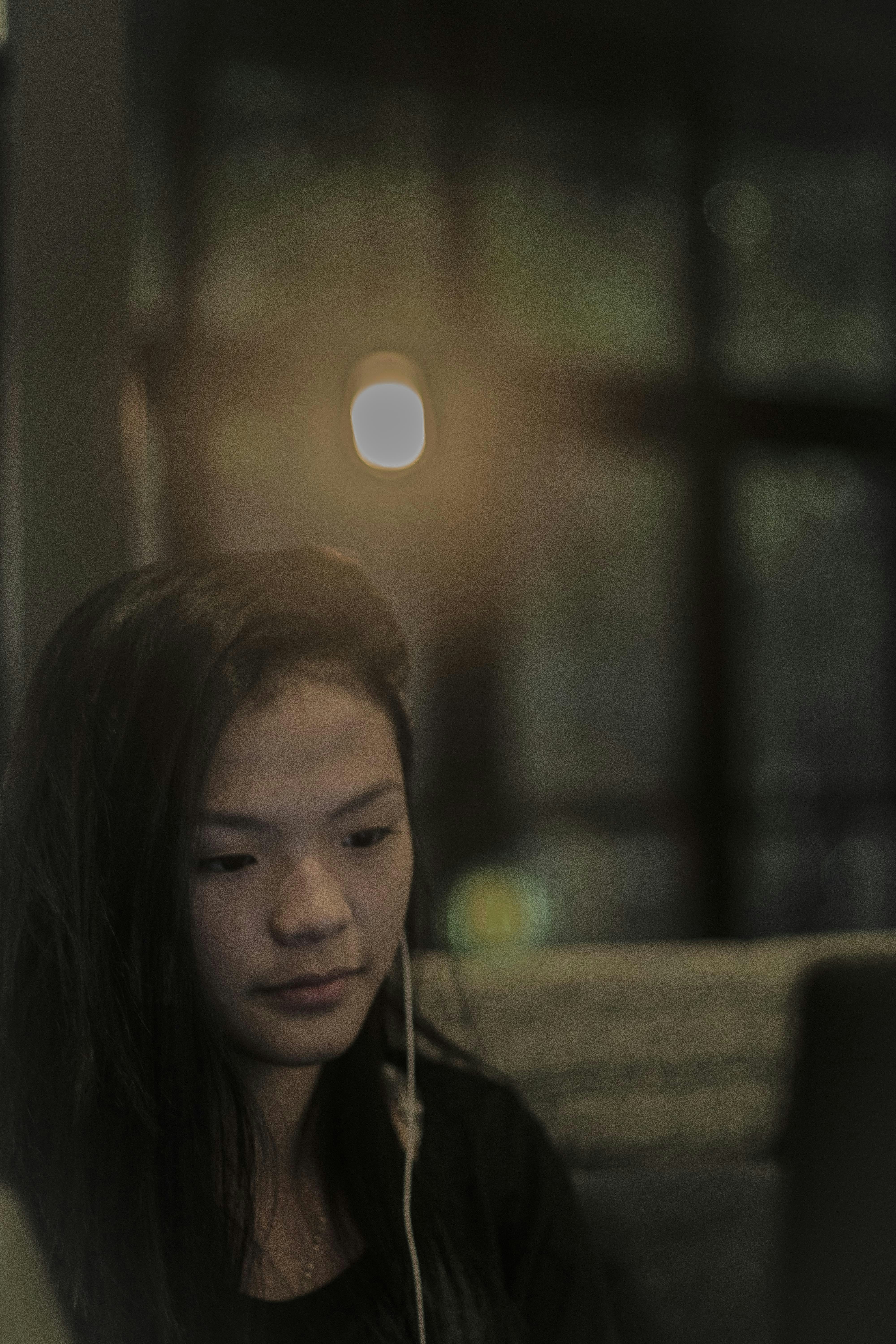 Portrait of a smiling Latina woman enjoying music with headphones in a cozy home setting.