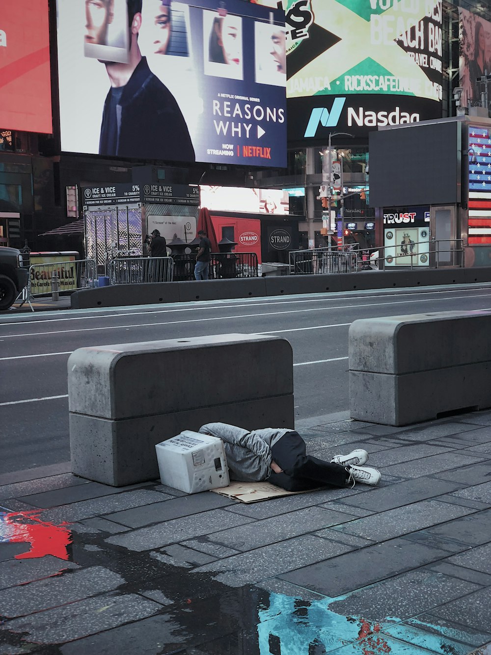 person laying on concrete floor beside asphalt road