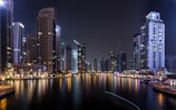 lighted city buildings beside body of water