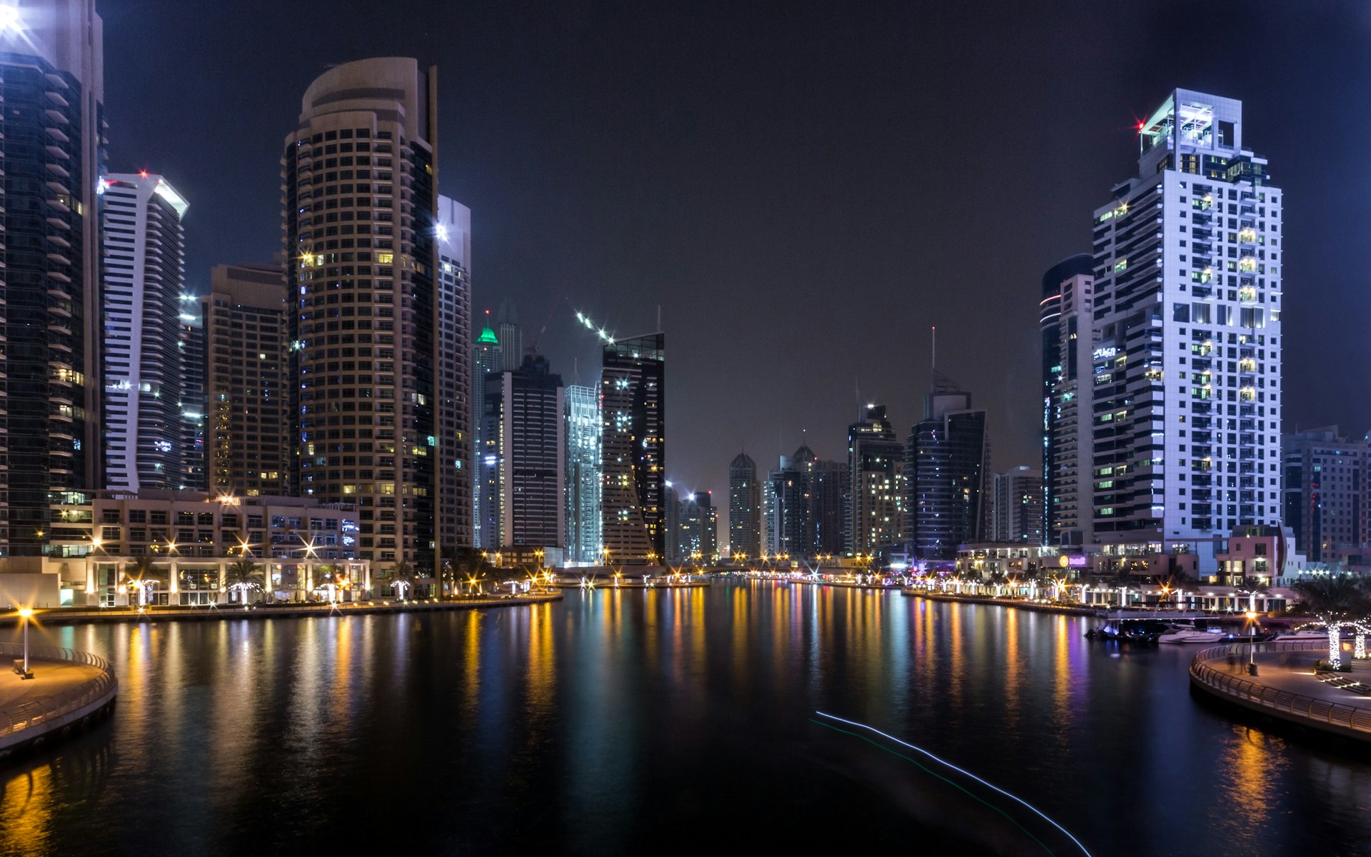 lighted city buildings beside body of water