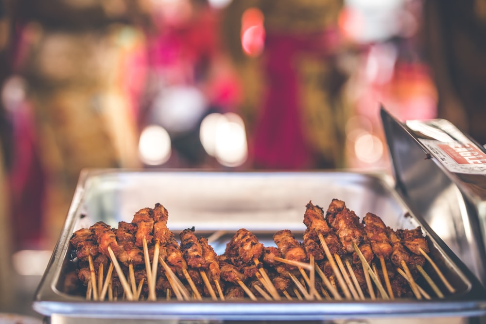 Photographie sélective de brochettes de porc sur plateau