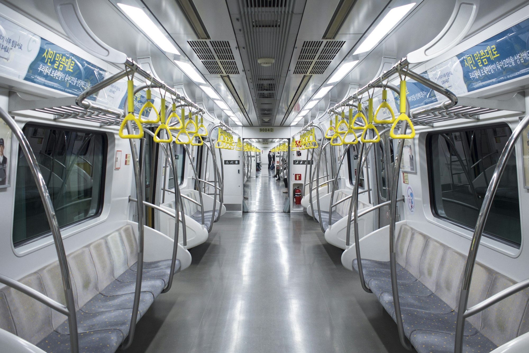 An almost empty train in the afternoon in Seoul, Korea. I was drawn by the contrast between the vibrant yellow handles and the bright, clean train.