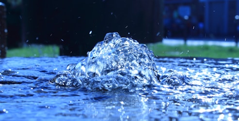 Close-up of a sleek Enagic Kangen water machine filtering water with droplets sparkling.