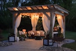 photo of gazebo with curtain and string lights