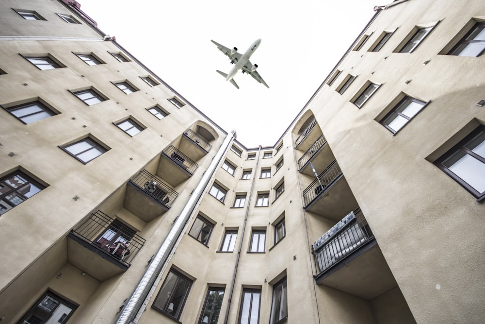 worm's-eye view photography of building and airplane