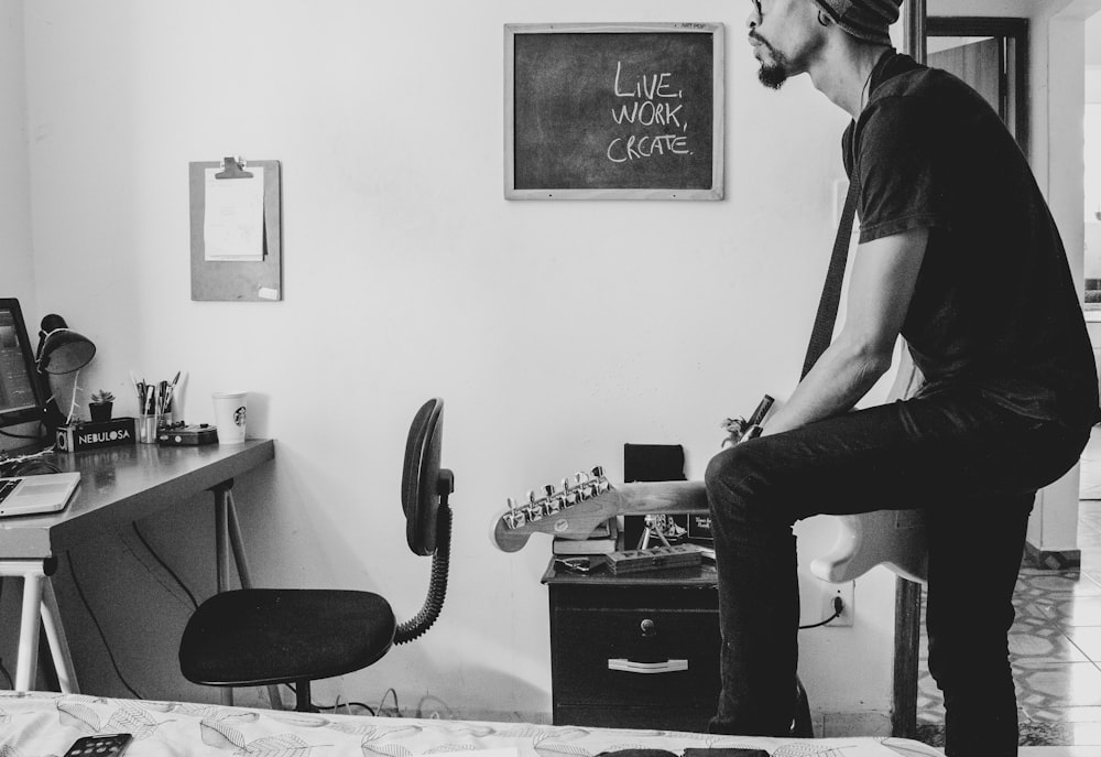 Foto in scala di grigi di un uomo che suona la chitarra