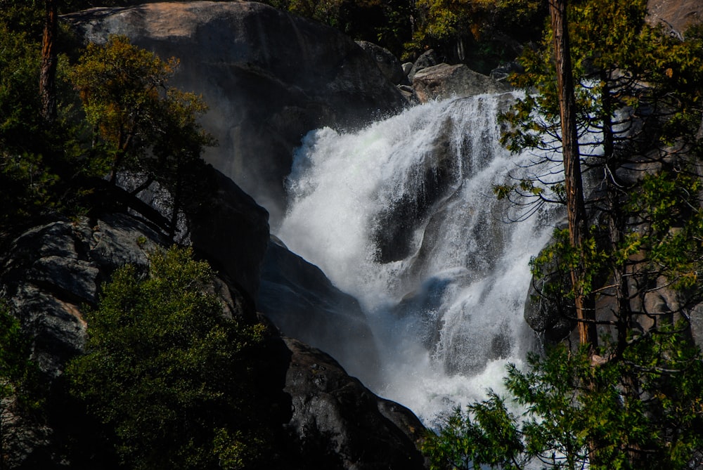 Cachoeiras ao redor da montanha com árvores fotografia da natureza