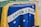 A close-up of the Brazilian flag displaying the green, yellow, and blue sections with white stars and the phrase 'Ordem e Progresso' prominently. The fabric appears to be slightly wrinkled, indicating it is draped over a surface.
