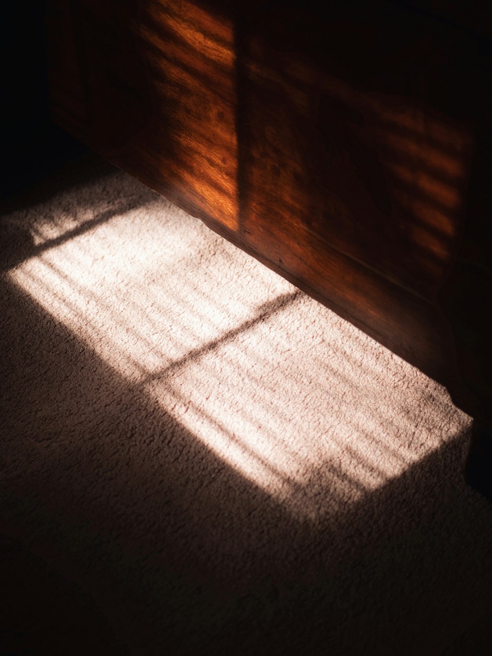 a luz do sol está brilhando através da janela para o chão