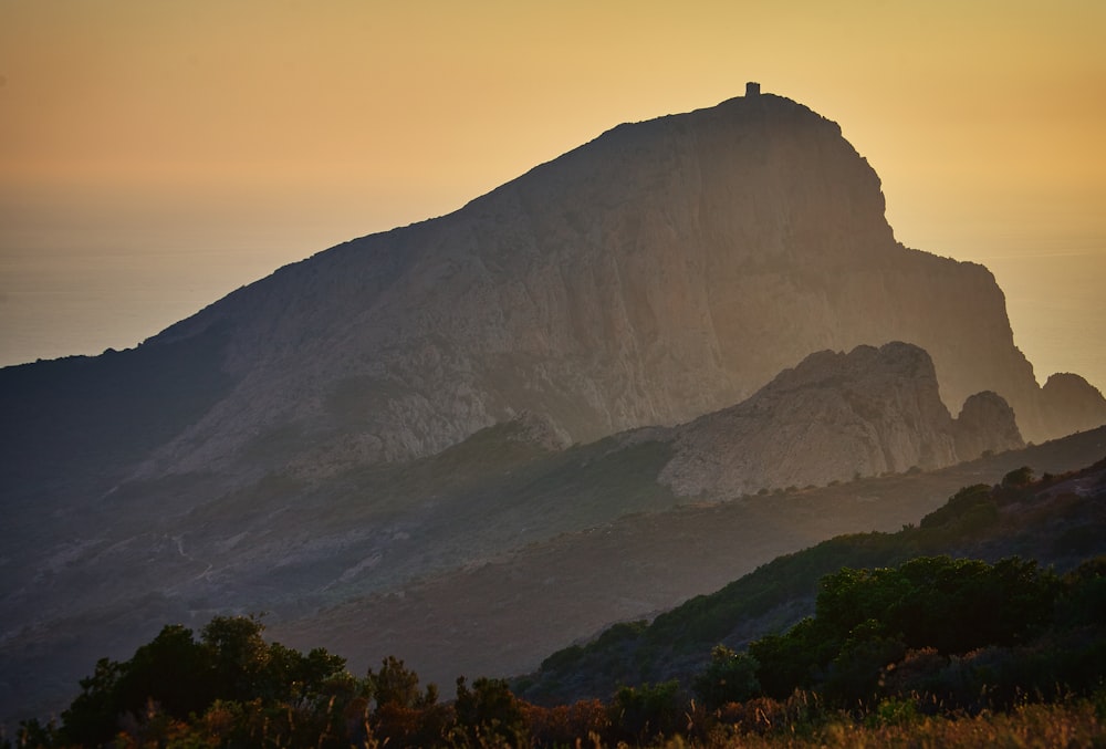 mountain covered with smoke during golden hour