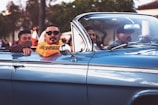men ridding vintage convertible car