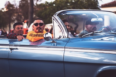 men ridding vintage convertible car