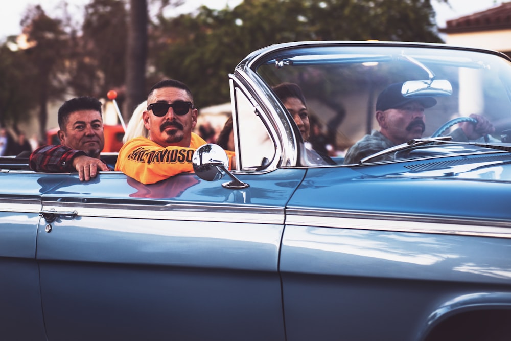 men ridding vintage convertible car