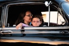 girl and woman inside black car