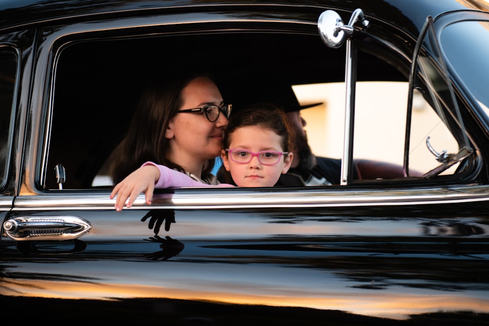 girl and woman inside black car