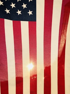 A close-up of a waving American flag with sunlight streaming through.