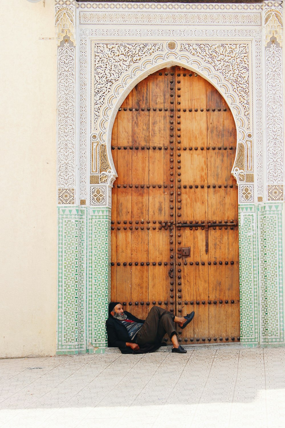 man in black pants sitting beside door