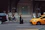 A professional chauffeur opening the door of a luxury sedan for a business traveler in a bustling cityscape.