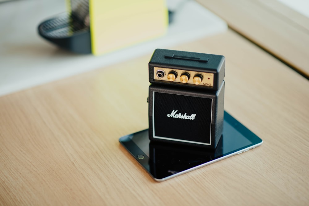 black Marshal guitar amplifier on speaker on smartphone