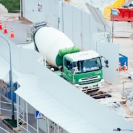 green and white mixer truck at the construction site