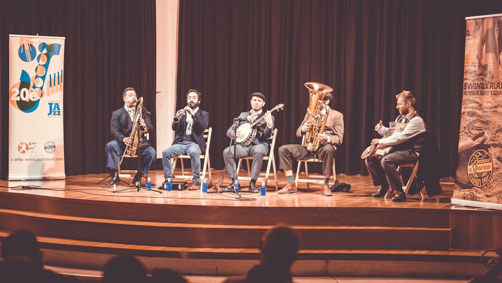 five men playing instruments on stage