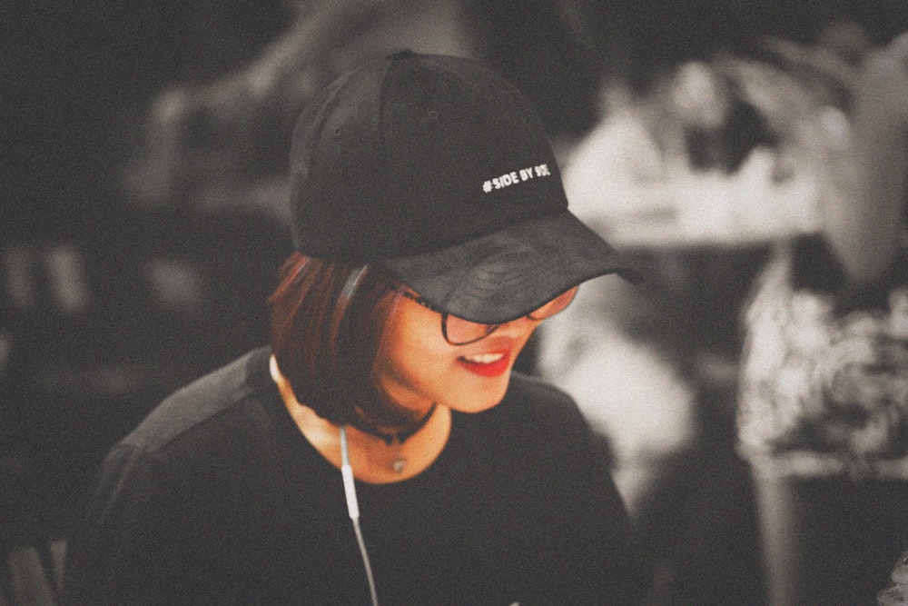 Selektive Farbfotografie einer Frau mit schwarzer, taillierter Mütze