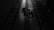 A dimly lit industrial setting with two cables running vertically along a textured floor. There are mechanical components in the center, casting shadows due to the minimal lighting.