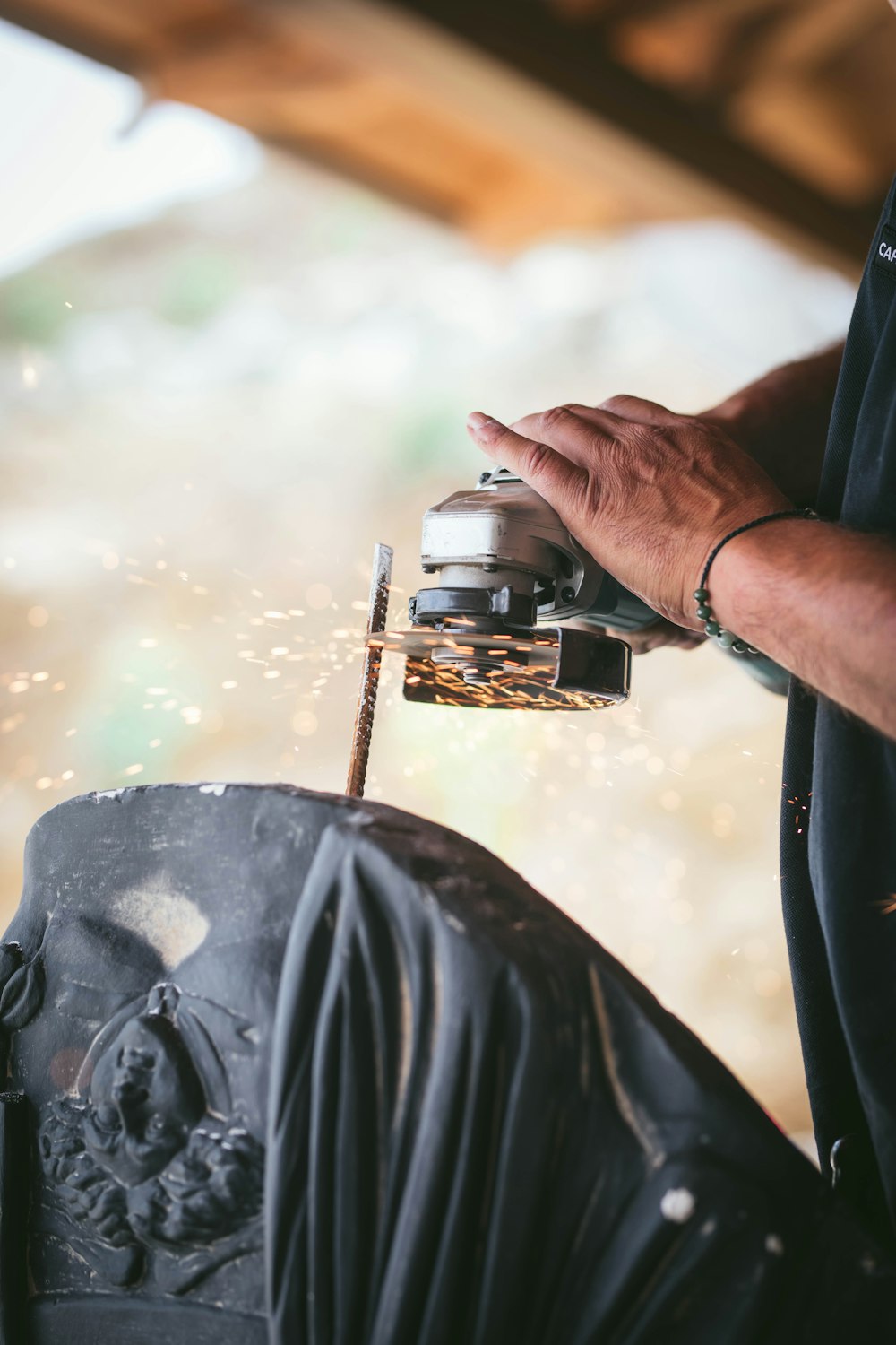 person using gray angle grinder