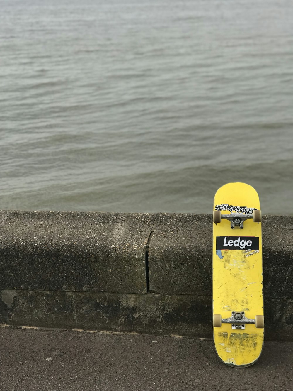 Planche à roulettes Ledge jaune près d’un plan d’eau
