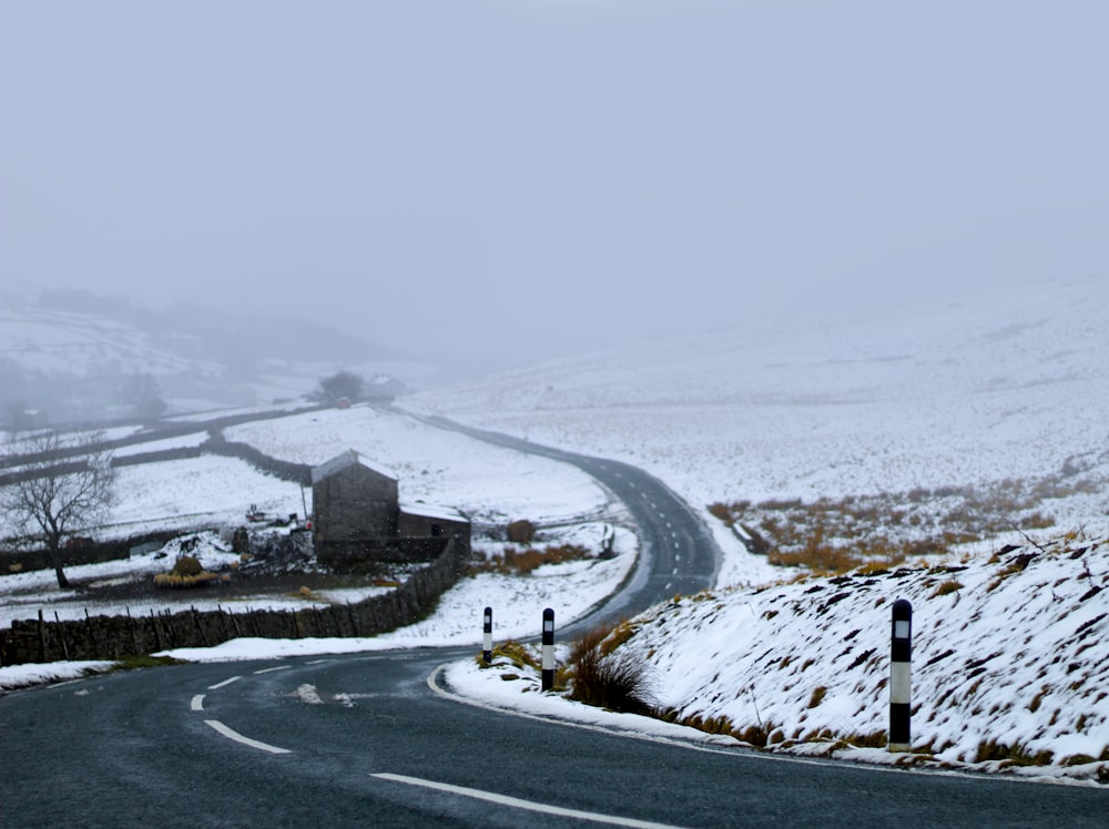 estrada de asfalto entre campo coberto de neve durante o dia