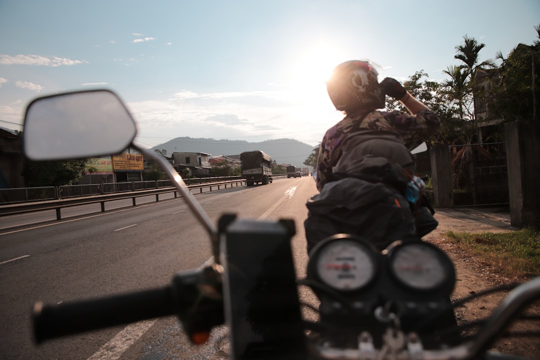 man driving motorcycle on road