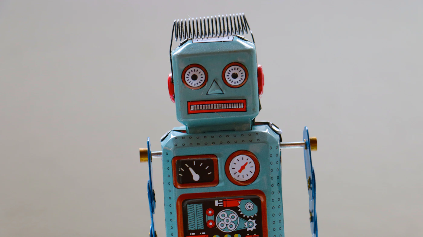 Friendly blue plastic robot toy — AI and ChatGPT jokes 2026