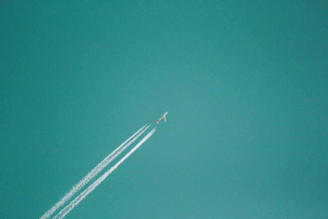 flying jet plane releasing white smoke