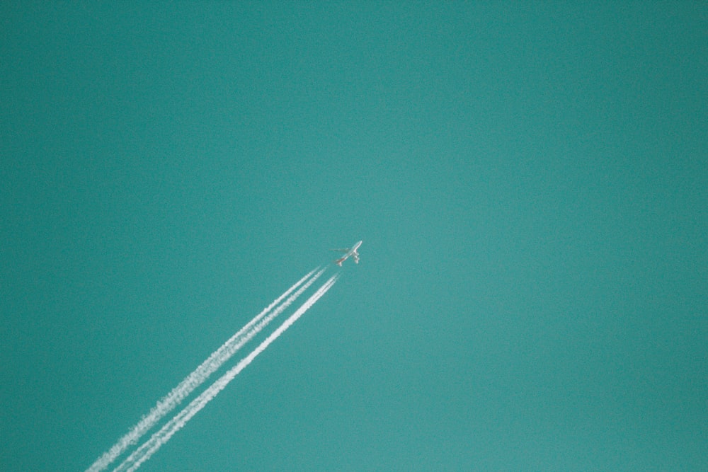 flying jet plane releasing white smoke