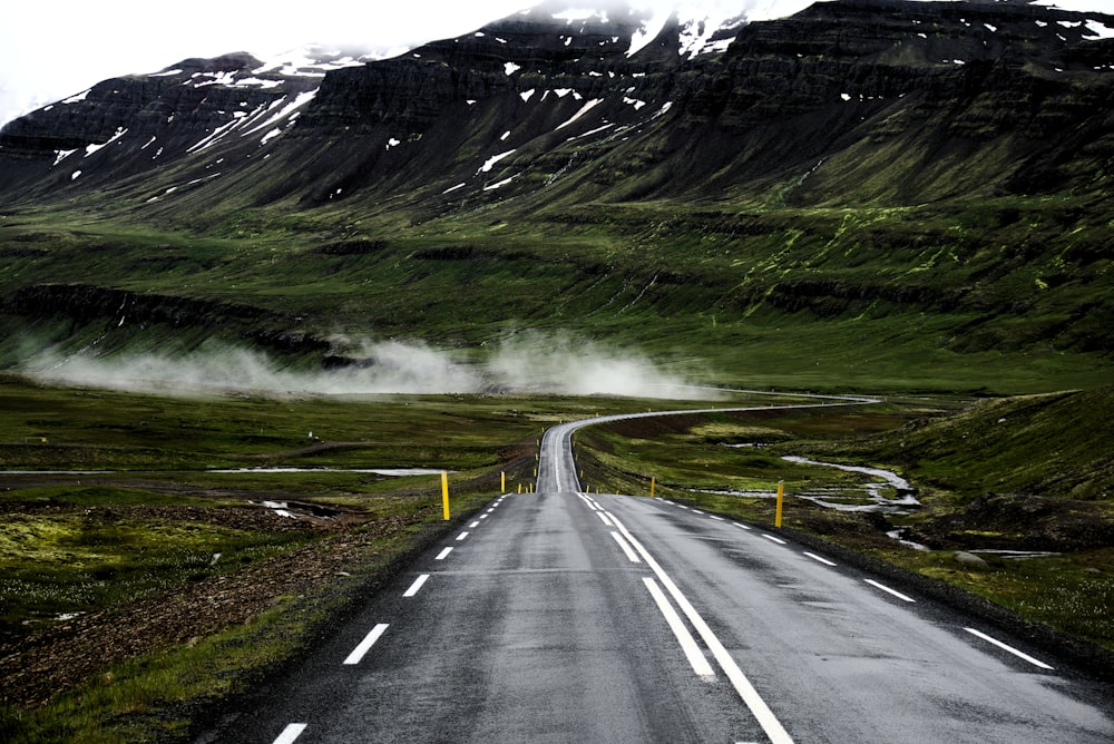 Strada in cemento grigio che attraversa la montagna