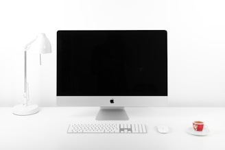 Minimalist workspace with a laptop and a cup of coffee on a clean desk.