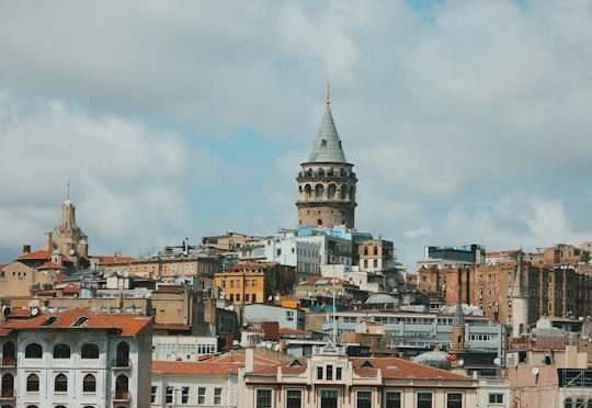 architectural photography of concrete structures under cloudy sky in Galata Tower Turkey