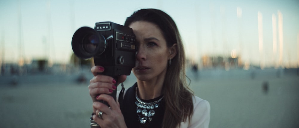 selective focus photography of woman holding camera
