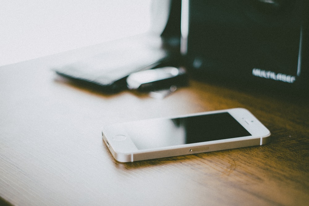 gold iPhone 5s on brown wooden surface