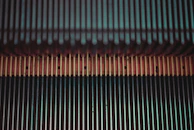 Escalator steps moving with a focus on the mechanical and electronic parts beneath.